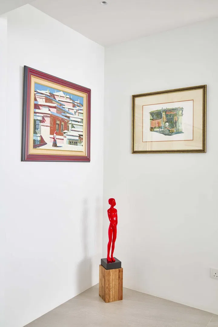 Framed artworks on the wall sandwich a Chen Wen Ling sculpture.