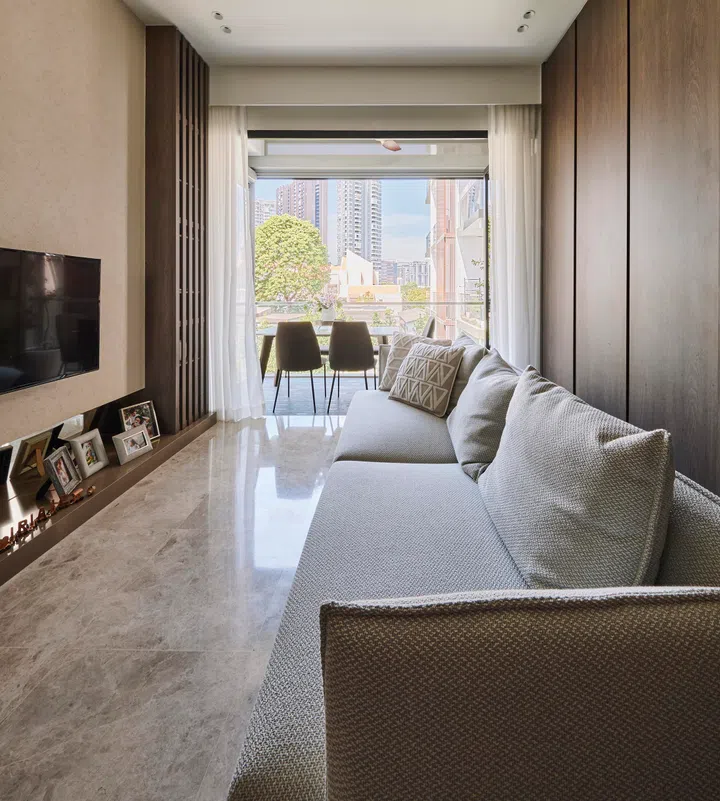 Slatted wood panels and a seamless TV wall define the resort-inspired living area, anchored by the couple’s King Living sofa.