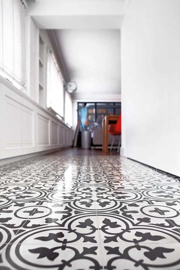 The foyer’s patterned floor tiles make a striking introduction to the home’s European theme.