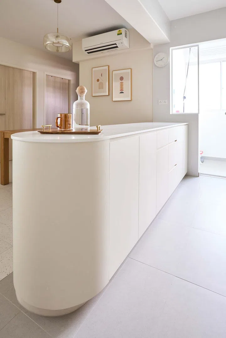 Rounded edges for this kitchen island in a minimalist 5-room HDB BTO in Tampines.