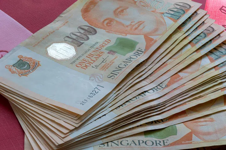 Singapore SGD 100 One Hundred Dollars Stack Fan Out on Red Packet Background.