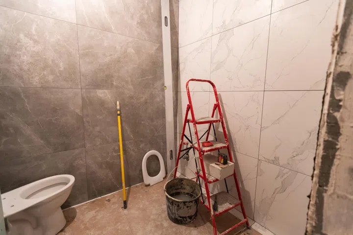 Bathroom renovation and tiling. Laying floor ceramic tile.