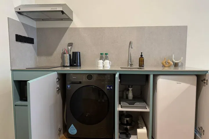 Fully functional kitchenette with a washer dryer machine, bar fridge, and hob. Just like a small condominium.
