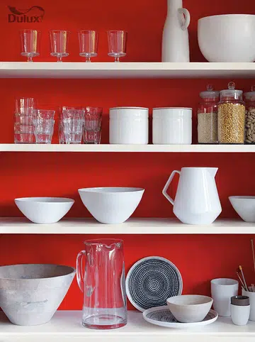 A bright chilli red wall paint background for open kitchen shelves. Image by Akzo Nobel.
