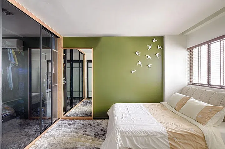 A green wall gives the master bedroom a fresh vibe. Simple decorations such as the bird wall decor, from Spotlight, add a fun touch.