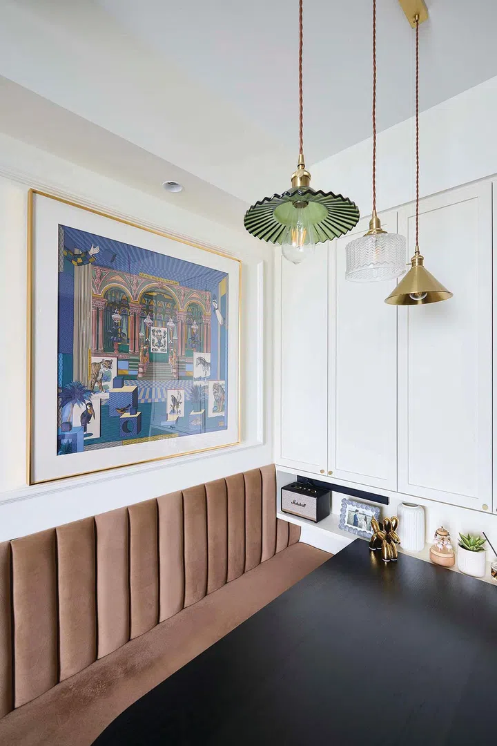 Cushioned dining bench backrest and a framed artwork adorn the dining area walls in interior designer Vivian Chen (of Muwu Construction) and financial advisor husband, Michael Chan's 635 sq ft 2-bedroom condominium along Stirling Road.
