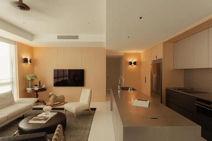 Wood, steel, and fabric materials harmonise with the reflective architecture beyond, creating warmth within a modern frame.