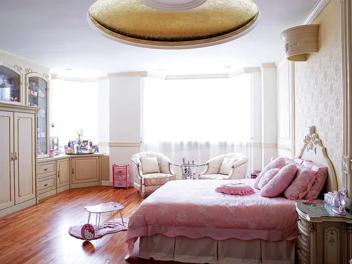 The ceiling of the attic-level master bedroom was specially sponge-painted to create a dreamy effect, like that of clouds floating in the sky. The master bedroom exudes a dignified air with grand gestures like the round ceiling alcove above and bespoke furniture.