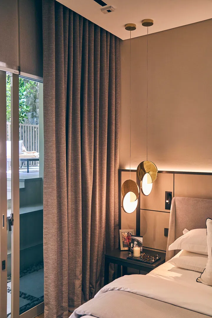  Rich curtains help manage daylight and privacy, while pendant lighting keeps the room calm and inviting.
