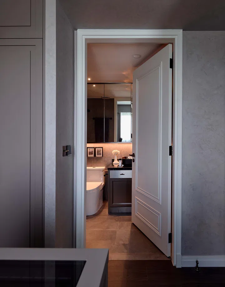A sleek, modern toilet door complements the bathroom’s elegant finishes.