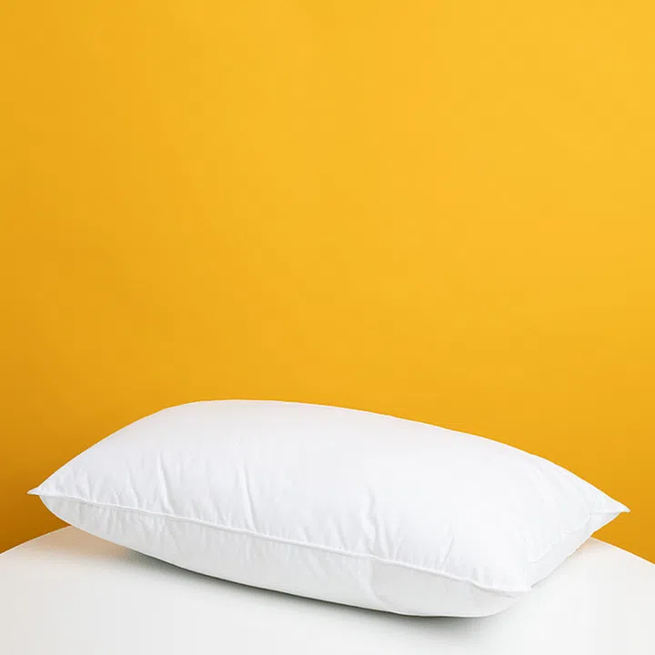 pillow on a bed against a yellow wall background