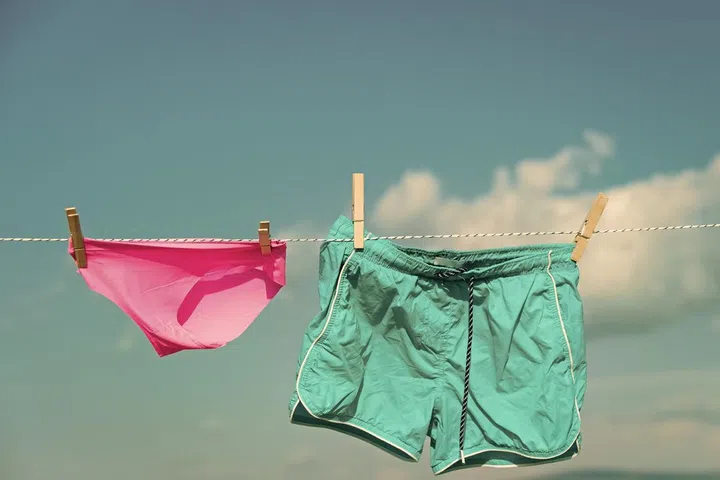 Laundry clean of short and pants on clothespin and clothesline.