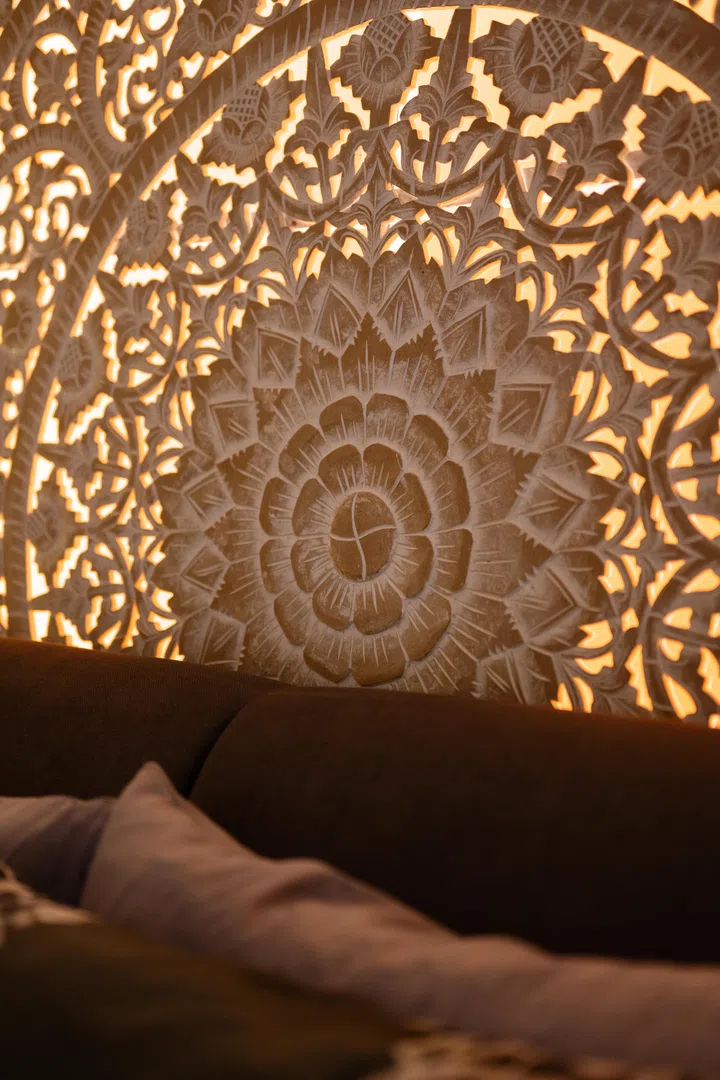 Intricate hand-carved details reveal the craftsmanship behind the custom Balinese panel that inspired the master bedroom’s design.