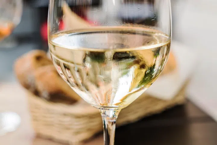 Glass of white wine on an outdoor terrace table.