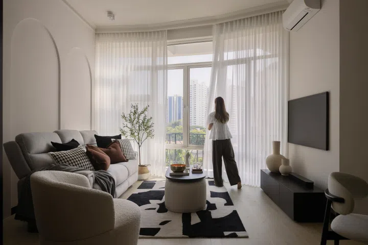 Homeowner of the 3-bedroom condominium in Tanglin (1,399 sq ft) draws the curtains in the living room. Interiors designed by Studio HP.