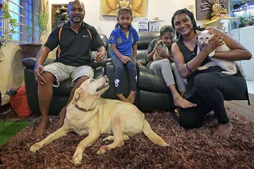 Mr Pragalathan Ramiah and his wife, Lalitha, train their daughters Shaistha, nine, and Tishah, four, to help care for their pet dog and two cats. ST PHOTO: ALPHONSUS CHERN