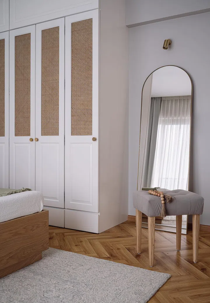 Natural materials such as wood and rattan introduce warmth to the guest bedroom in this 2-bedroom apartment in Parsi, Mumbai.