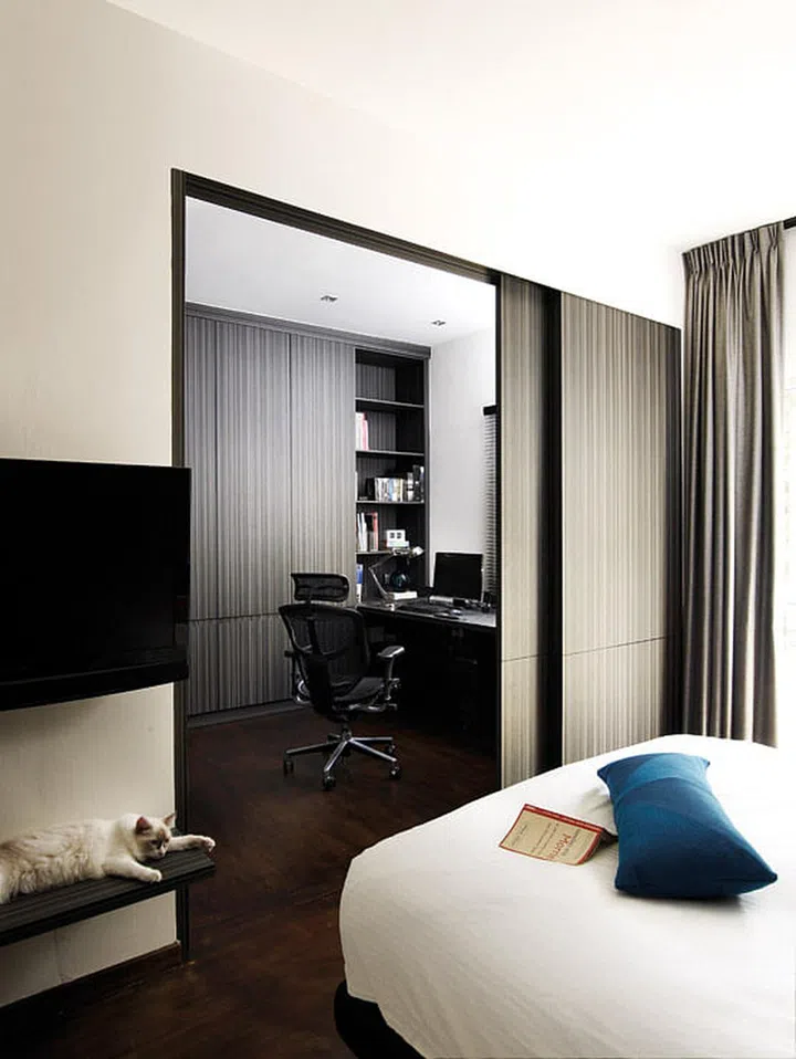 Sliding doors separate the study and walk-in wardrobe space from the bedroom, while a pillar doubles as a TV console.