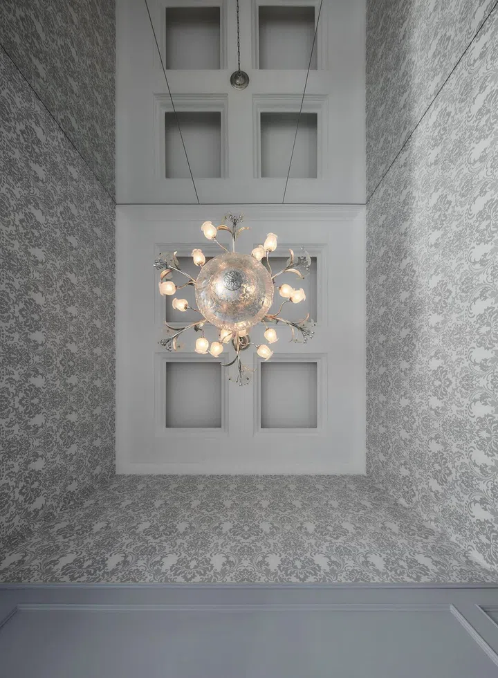 A chandelier adorns the 4.2m high ceiling in a flight steward's 2-bedroom with study condominium along Sims Drive designed by The Cottage Crafts.
