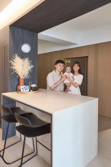 A 31 and a 30-year-old Architectural Designer Couple poses for a photo in their 4-room BTO (1,001 sq ft) in Punggol with their baby.