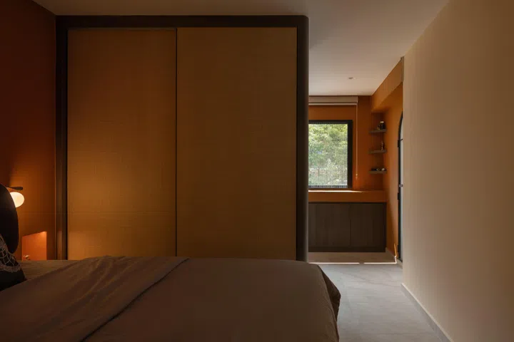 A full-height two-way wardrobe separates the sleeping area from the prayer space, allowing either side to be used independently without disturbing the other.