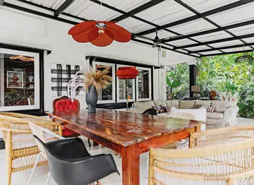 The outdoor living and dining area is a space to watch movies and have long dinners with family and friends. A vintage chair belonging to Barbara’s grandmother has been upholstered in pink velvet that stands out while also complementing the rest of the decor.