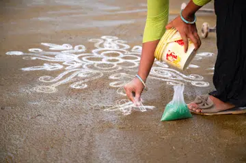 Kolam Rangoli, colorful sand painting drawing, women and girls at evening of Holi festival in India, Indian religion and culture, Hinduism celebration.