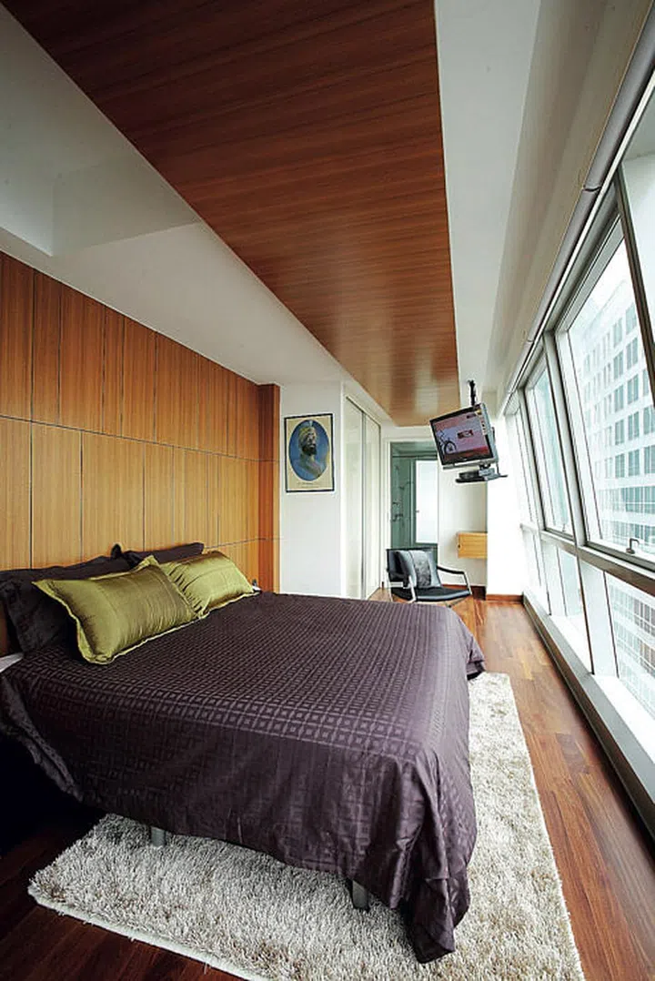 Replicating the design of the kitchen’s tiled feature wall in the bedroom but in a different material (timber veneer) gives the spaces an appealing visual continuity. Stretching down the length of the master bedroom, the timber panel above pulls the long and narrow space together visually. Silky pillows and cushion, from Haier Living.