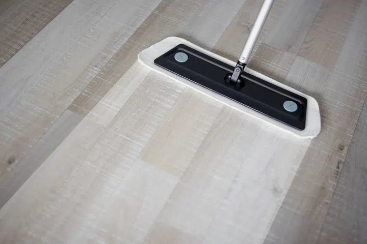 before and after cleaning concept - close up of microfiber floor mop on wooden background