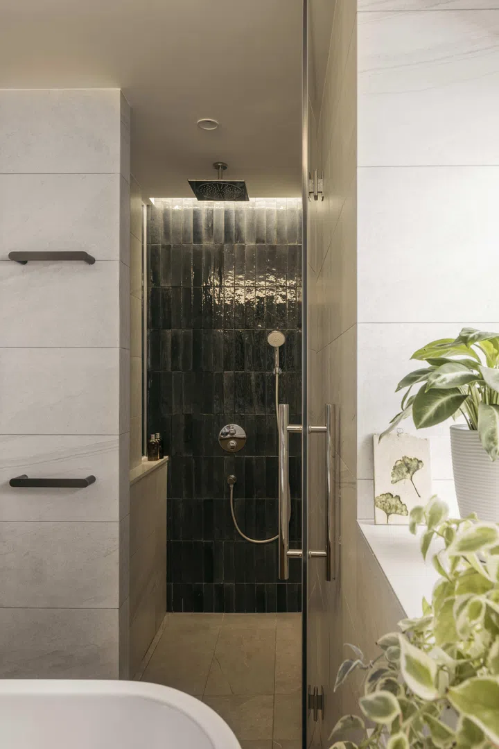 Finished in jade green tiles, the shower becomes a small but deliberate feature—one of her favourite colours.