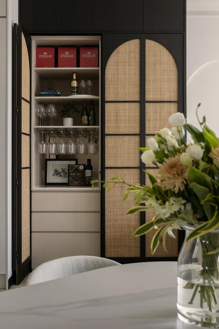 A home bar provides practical storage space for the couple’s glassware, as well as display their wine collection.
