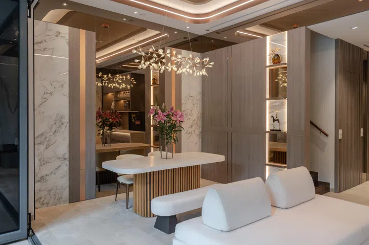 Custom pieces, including the two-sided sofa and dining table, help define the open-plan layout without making it feel crowded.