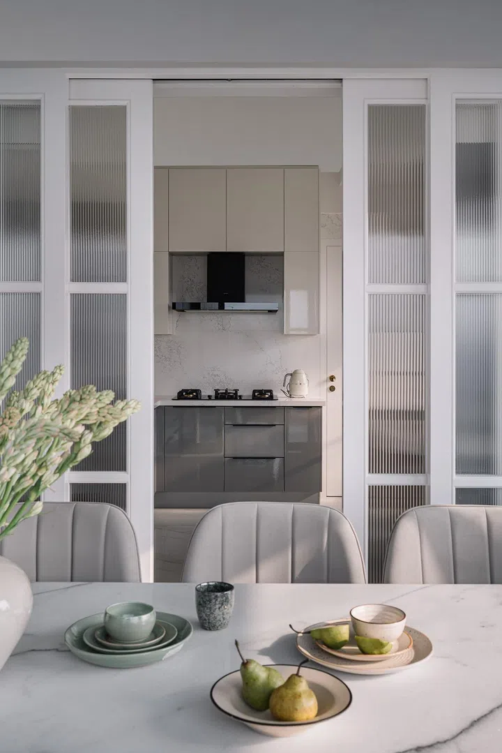 Fluted glass sliding door panels in this 2-bedroom apartment in Parsi, Mumbai.