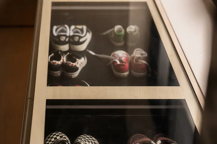 A glass-topped display preserves the children’s first sneakers and other memorable family pairs.