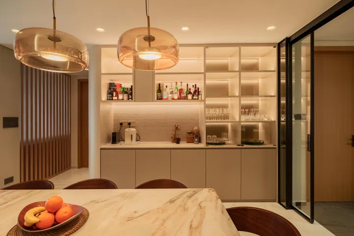 Integrated storage, softly lit shelving, and a drinks station make the dining enclave a natural gathering point for both everyday family meals and regular hosting.