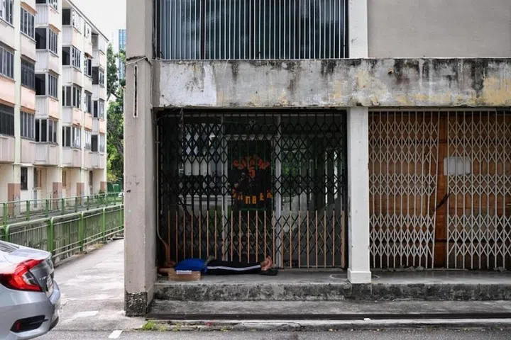 A man having a nap outside one of the former shops on the ground floor of Block 1 in East Coast Road on Oct 3, 2024.