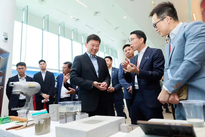 Minister for National Development Mr Chee Hong Tat viewing an ultralowcarbon concrete demonstration developed through the Woh HupSIT collaboration.