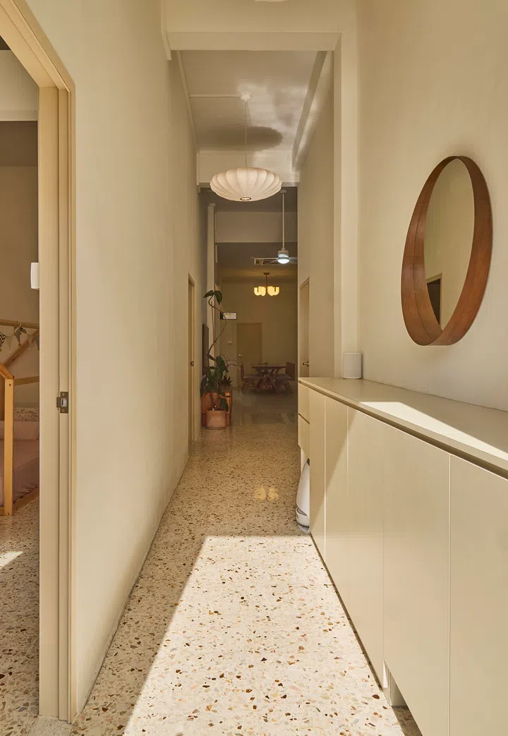 Low cabinetry lines the passage, keeping daily clutter contained while maintaining a clean, continuous spine.