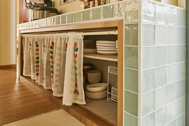 Originally intended for fluted glass doors, the pantry now hides behind embroidered café curtains—a simple solution Najiha wouldn’t change now.