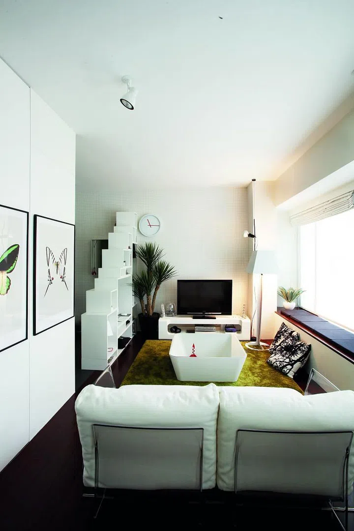 Light, natural or otherwise, brings out the best in tight spaces. In this case, the sunlit open-plan interiors are complemente with white walls that lift the space visually from its sombre, dark-stained wood floors.