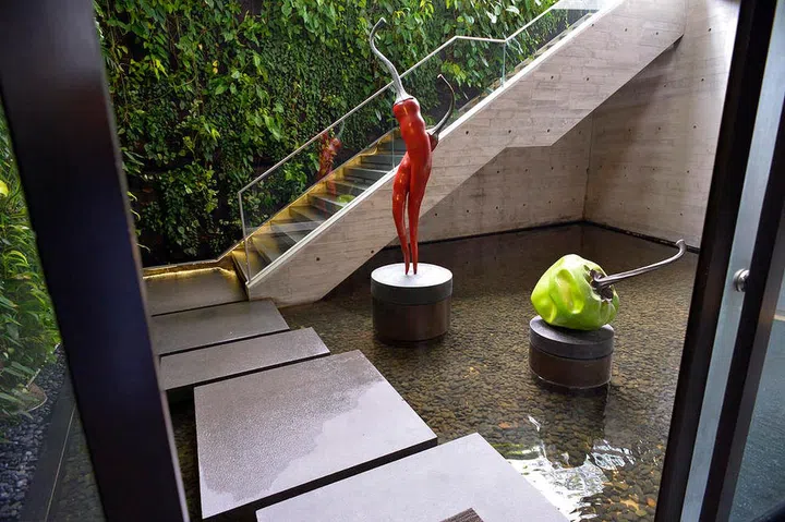 Chilli and bell pepper sculptures by Singapore artist Kumari Nahappan punctuate the entryway of socialite Susanna Kang’s Sentosa Cove home.