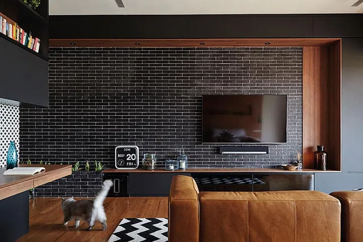 "Black is the new white," proclaims Terence, on his extensive use of black in his room. Black brick walls and a black-and-white zigzag-patterned rug add texture and detail to the room.