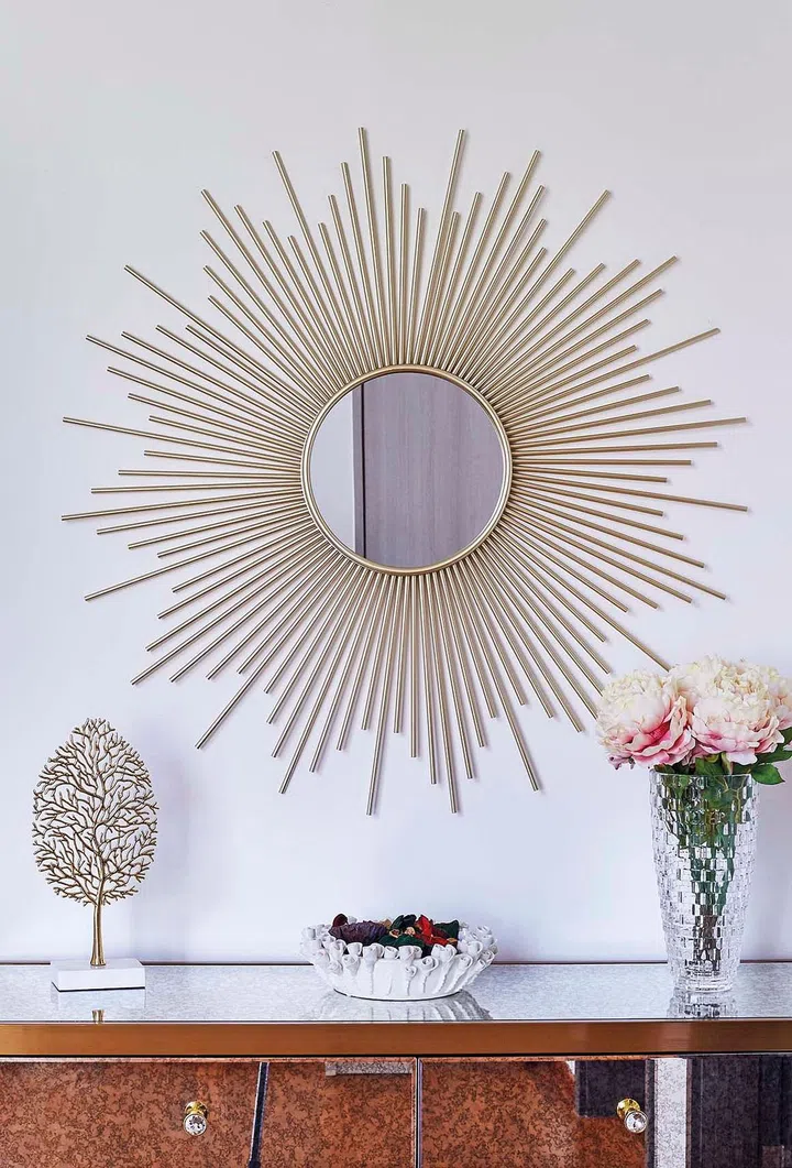 Gold sundial mirror adorns the wall above a console in this 4-storey terrace house in Telok Kurau.