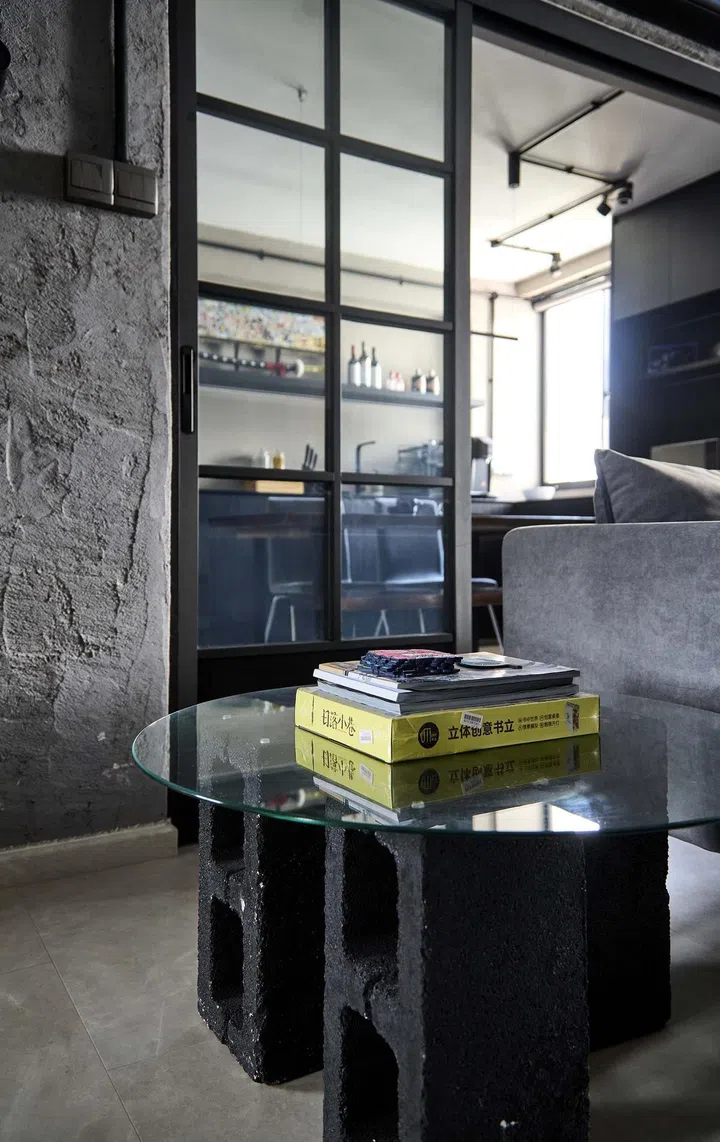 Brick and glass coffee table with books on display in flight attendant Kenny Shoo’s 3-room HDB flat at Tampines Street 41.