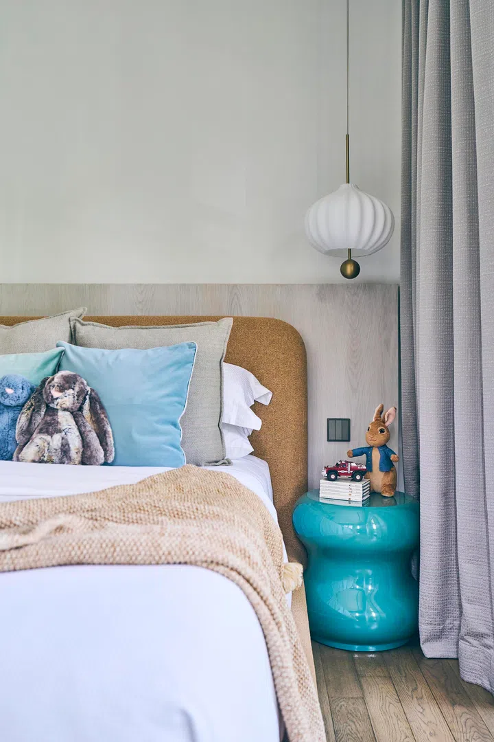 Soft textures and whimsical touches—like plush toys and a turquoise side table—make the rooms cosy as well as fun.