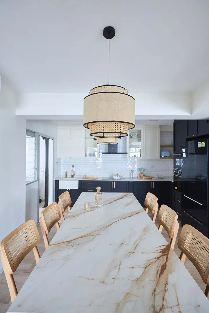 Rattan dining chairs and a pair of matching pendant lamps at the kitchen island dining table.