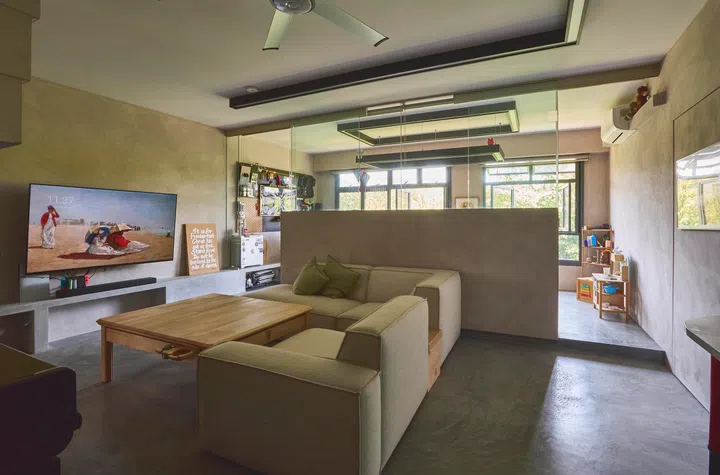 An L-shaped sofa abuts a concrete half-wall in the living room.