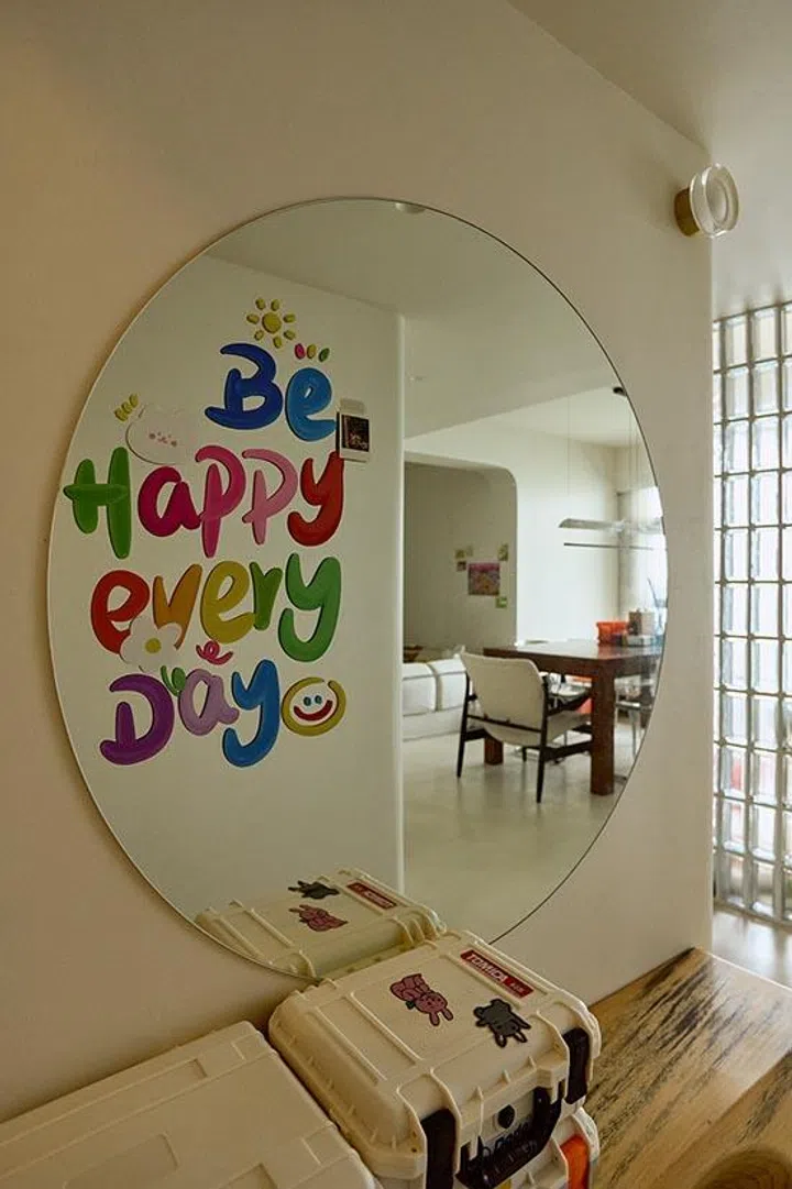A round mirror personalised with a colourful decal turns a simple functional piece into a daily mood-lifter at the threshold of the home.