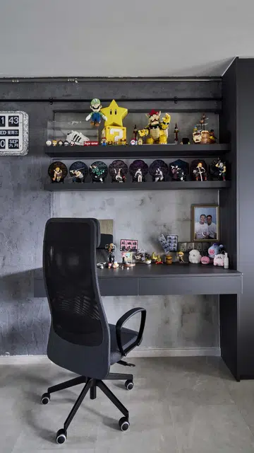The cement screed wall continues to the study corner towards the right, where figurines from Kenny’s favourite Japanese anime series, Demon Slayer: Kimetsu no Yaiba, and hand-pieced Super Mario Bros. Legos are displayed on two wall-mounted shelves above the desk.  