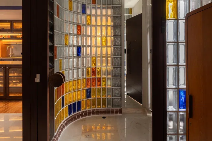 A curved glass block screen at the entrance foyer affords light.
